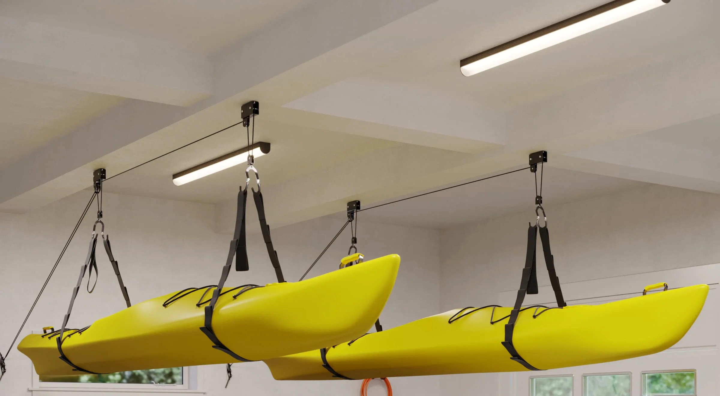 Two kayaks on the hoists under a garage ceiling